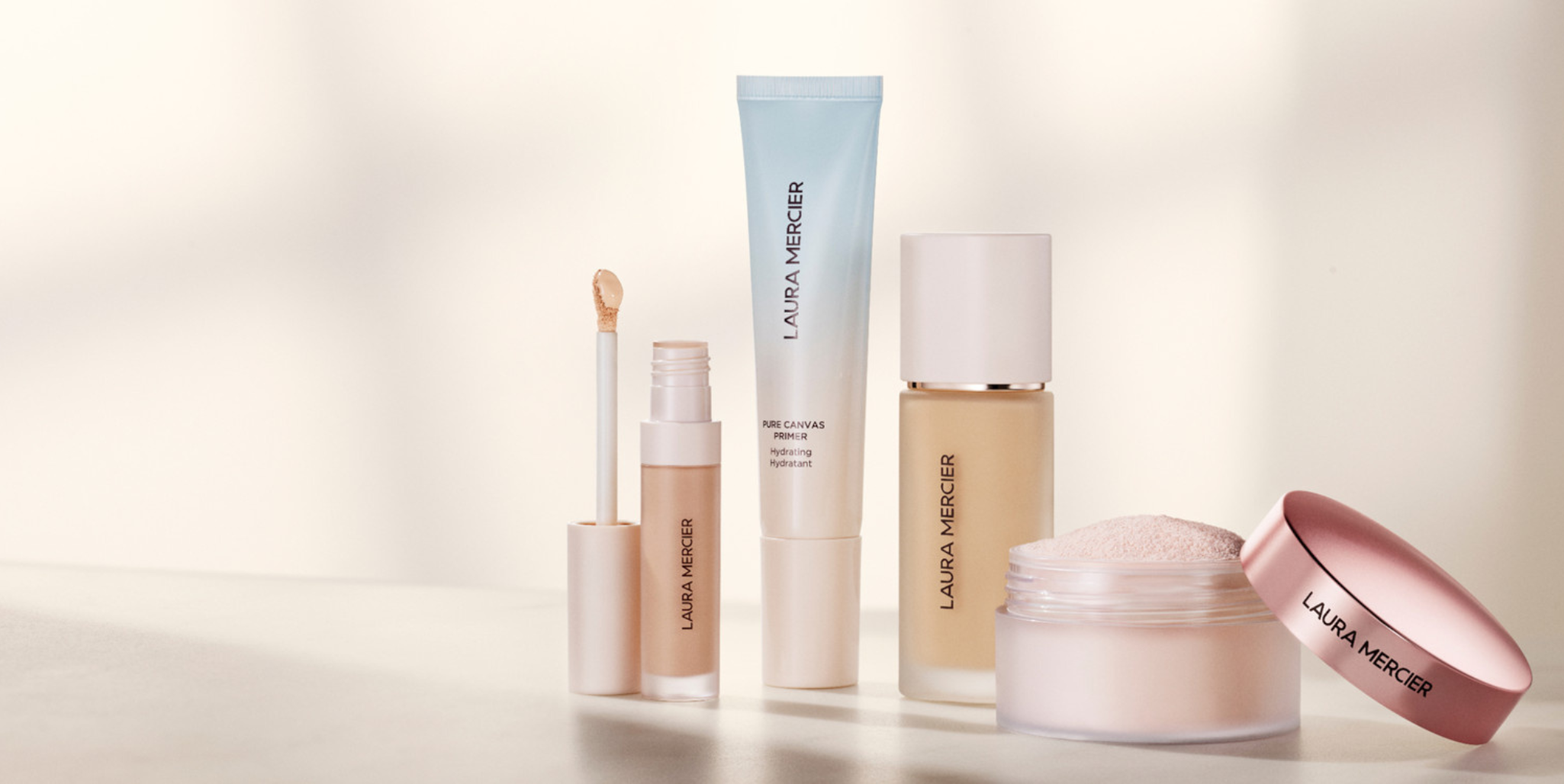 Laura Mercier Real Flawless Foundation and Concealer, Pure Canvas Primer, and Translucent Loose Setting Powder in Tone up next to eachother